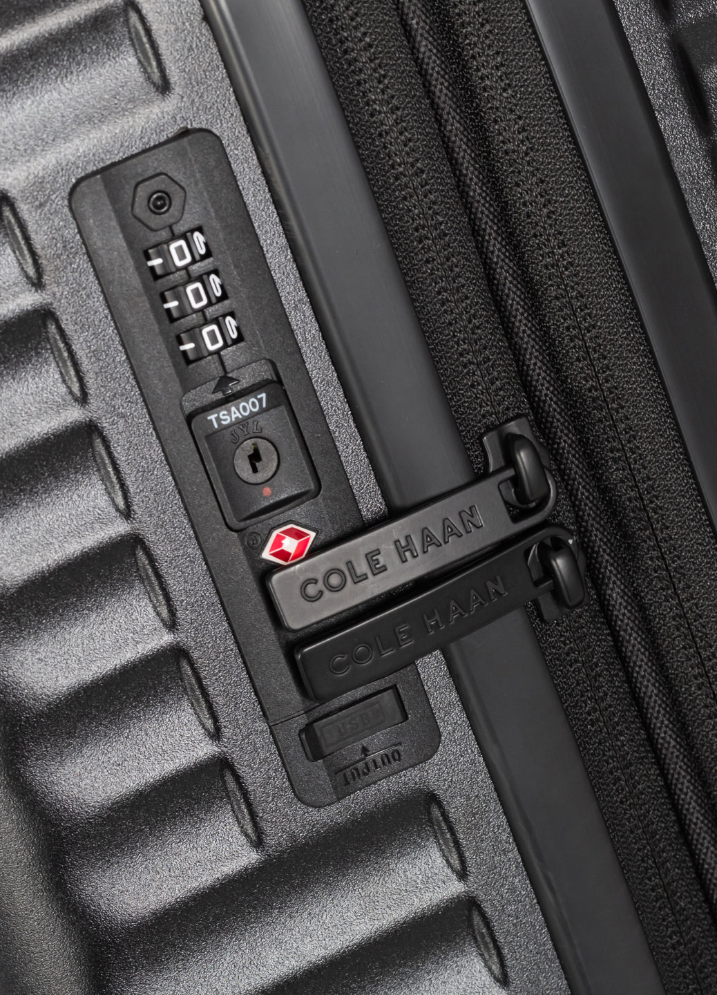 Close-up of a black Cole Haan suitcase with a combination lock.