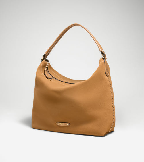 Tan handbag with a visible brand logo on a light gray background