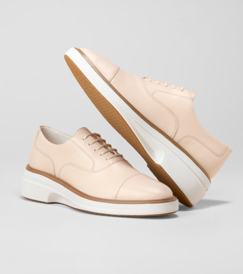 Pair of beige with white soles on a gray background
