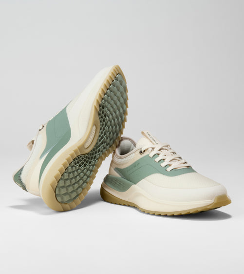 Pair of green and beige sneakers on a light gray background