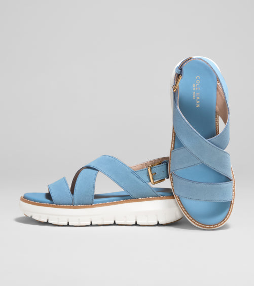 Blue sandal with criss-cross straps on a gray background