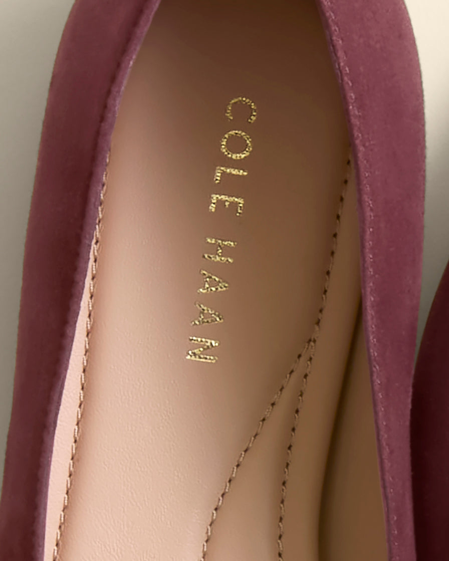 Close-up of a Cole Haan shoe with visible branding on a neutral background