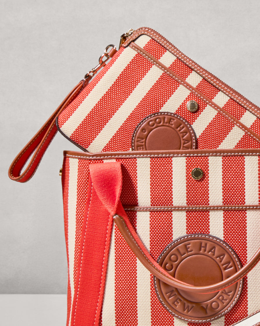 Red and white striped handbag with Cole Haan branding on a gray background