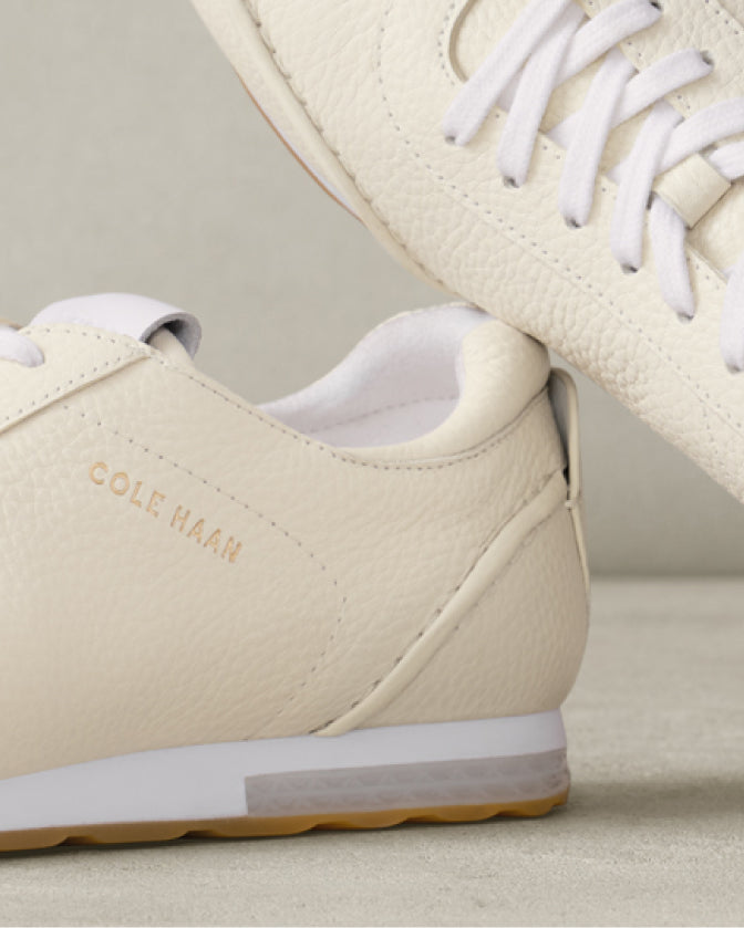 Beige sneakers with white laces and sole on a light background