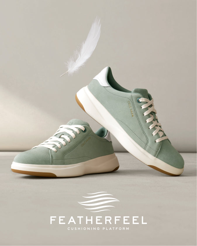 Pair of green sneakers with white laces on a light gray background, featuring the Featherfeel brand logo.