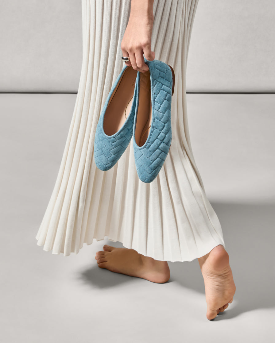 Woman standing holding blue Jasleen Quilted Ballets