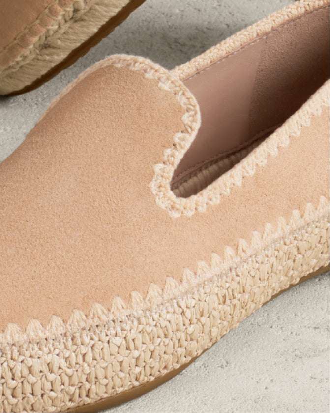 Close-up of a beige espadrille shoe with textured sole on a light background