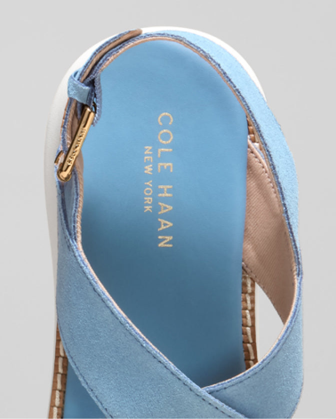 Blue sandal with 'Cole Haan' branding on a light gray background