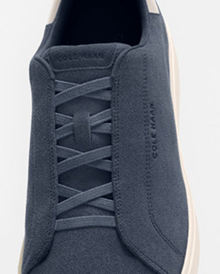 Navy sneaker with 'Cole Haan' branding on a white background