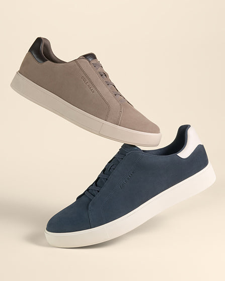 Two pairs of sneakers, one gray and one blue, on a beige background.
