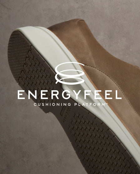 Close-up of a brown shoe with white sole on a gray background, featuring the Energyfeel logo.