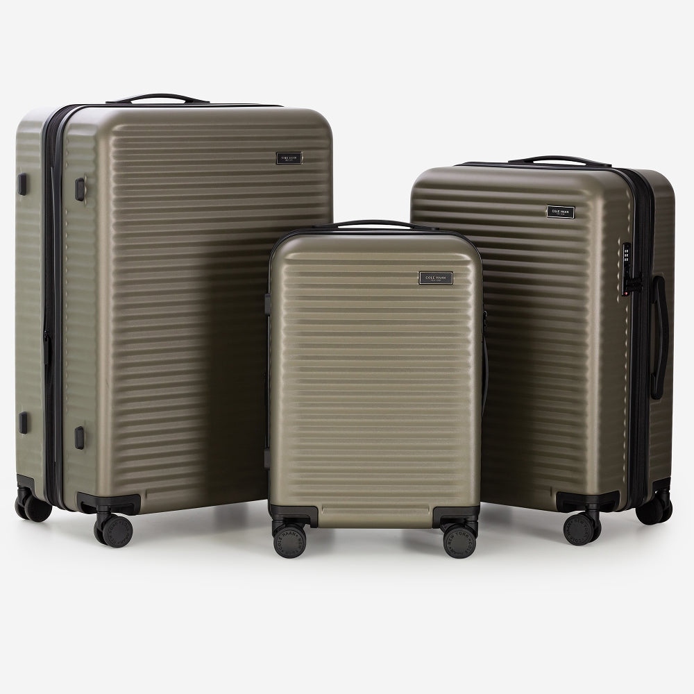 Three green suitcases of different sizes in a metallic finish on a white background