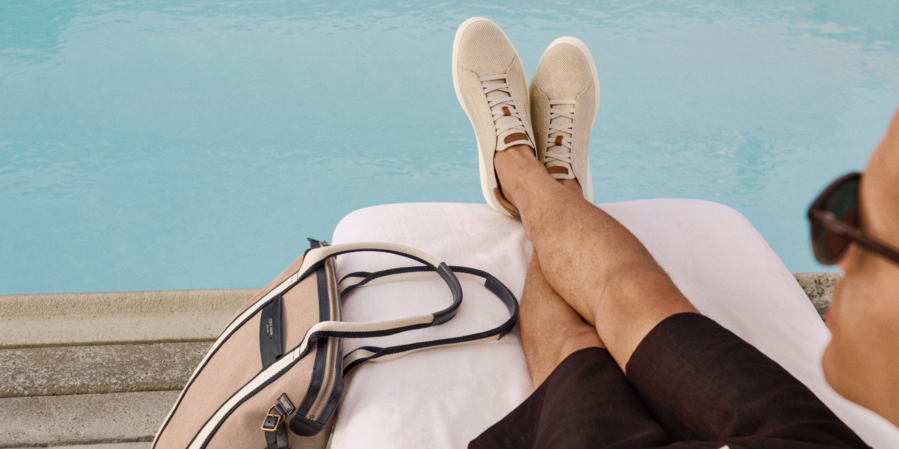 Man wearing beige sneakers by the pool