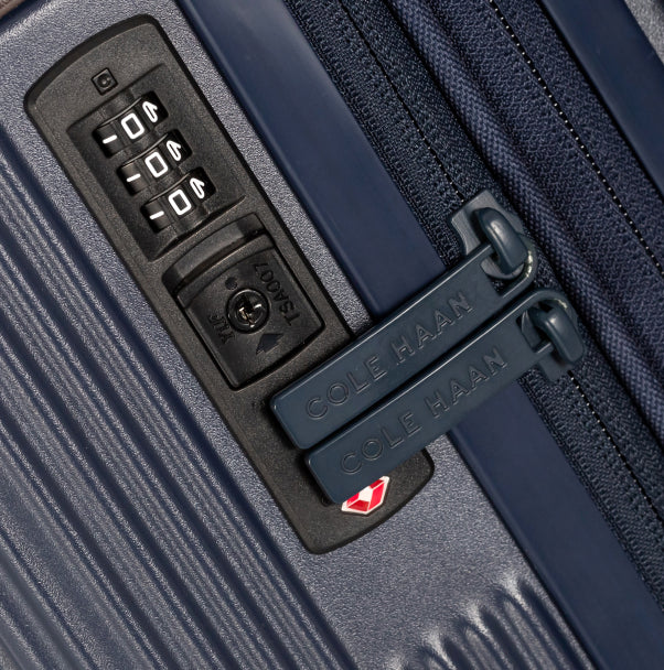Close-up of a Cole Haan suitcase with a combination lock and zipper.