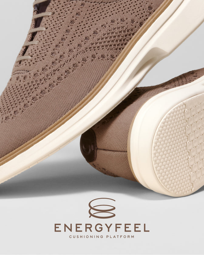Brown shoe with white sole on a light gray background, featuring the Energyfeel cushioning platform logo.