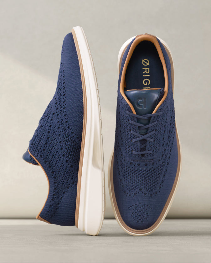 Navy blue sneakers with white soles on a light gray background