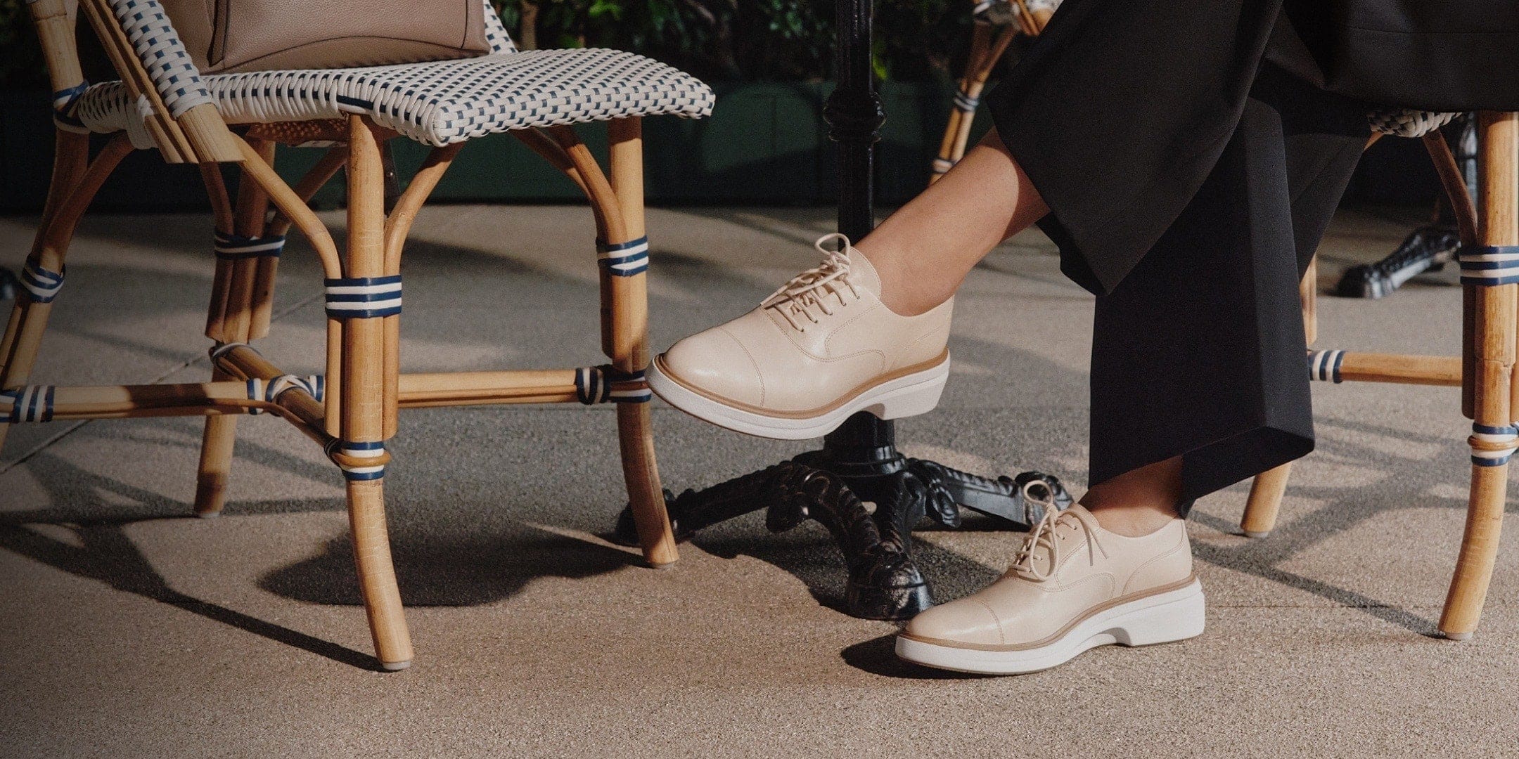 Person wearing beige shoes sitting on a chair with a blurred background
